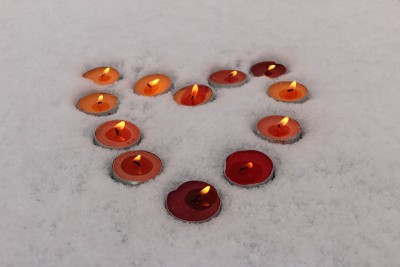 明亮的五彩蜡烛在雪地里排成心的形状