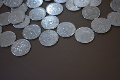 褐色背景的金属硬币，乌克兰格里夫纳和一便士，银行支付，财宝和现金支付，银行储蓄。
