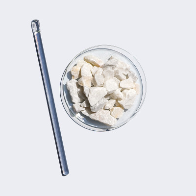 白色实验台上的化学成分特写。碳酸钙芯片在化学手表玻璃旁边搅拌棒。俯视图