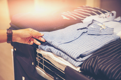 顾客在服装店挑选衣服的手