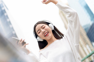 快乐微笑的亚洲女孩听音乐耳机