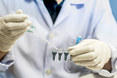 实验室技术员向微量滴定板中注射液体，实验室工作的科学家，血液分析，复古颜色。