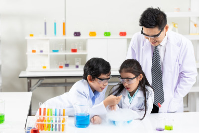 在实验教室里，孩子们在科学老师的陪同下做化学实验