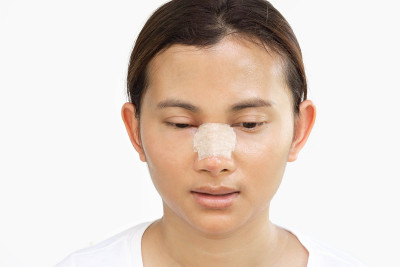 近脸的亚洲女性与鼻子整形美容的概念，白色的背景