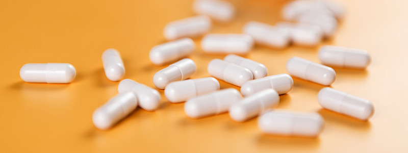 药物:白色药丸、片剂或胶囊，底色为黄色。