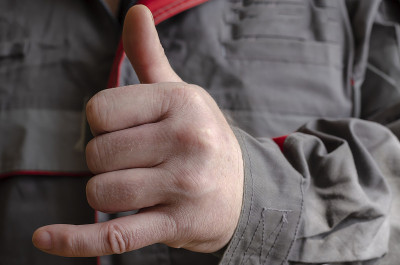 男子的手摆出了“shaka”的姿势。