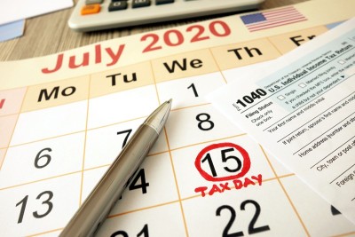 显示日期为2020年7月15日的月历，以1040表格计算器和笔标记为纳税日
