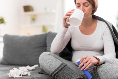 孕妇在一杯水中服用维生素片。