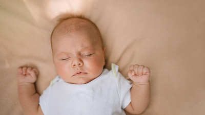 新生婴儿睡在柔软的床上。