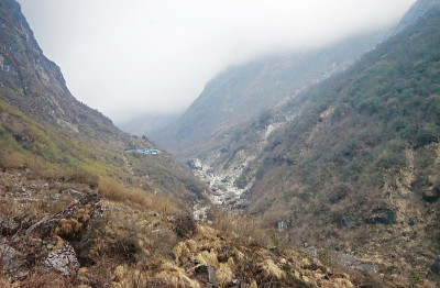 自然溪流之间的雪和岩石悬崖与蓝天