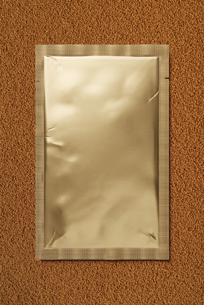 速溶咖啡颗粒上的金箔包。三维渲染