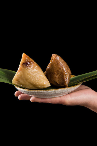 手拿粽子或粽子。端午节传统食品