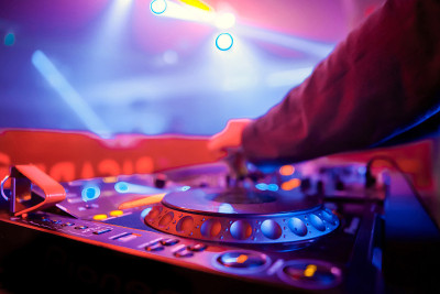 俱乐部dj在派对上播放音乐。夜总会音乐骑师在专业混音面板上调整声音频率。专注于dj手握调节器