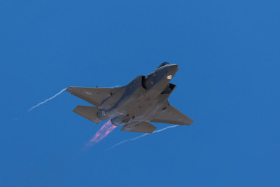 F-35闪电II接近，加力燃烧器打开，机翼尖端有冷凝尾迹