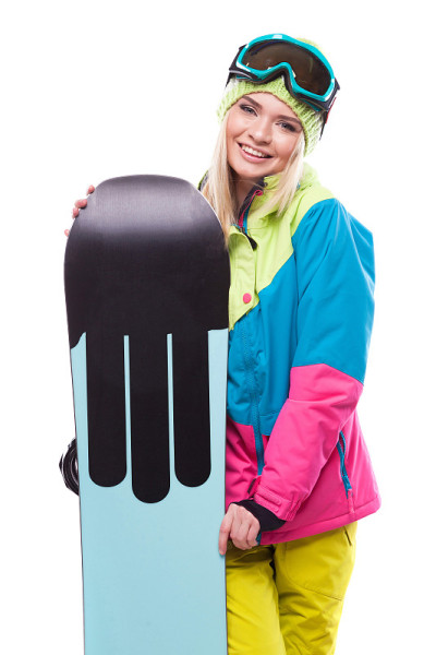 穿着滑雪服的漂亮年轻女子拿着滑雪板