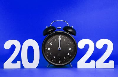 闹钟倒计时2021到2022年快乐新年，数字2022木制字与复古黑色时钟(0时钟)蓝色背景色-节日庆