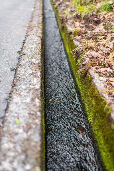在日本岐阜县，小排水沟沿着道路流着从融雪中流出的水