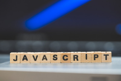 Javascript编程网络语言:在笔记本电脑上放置一个带有字母“Javascript”的木制立方体