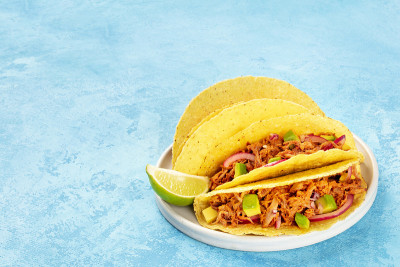 Cochinita pibil taco shells是一种墨西哥小吃，里面有拉猪肉、鳄梨和腌红洋葱