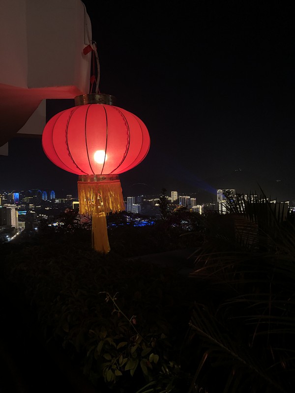 在三亚的灯光衬托下，中国传统的红灯笼在黑暗中闪闪发光