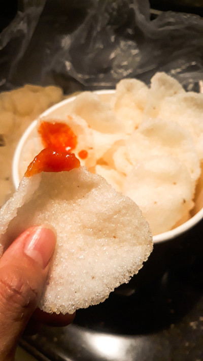一个女人的手拿着一块可以吃的饼干