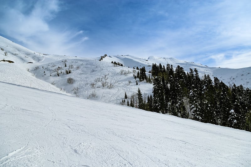 俄罗斯罗萨库特滑雪胜地美丽的山上覆盖着白雪。寒冷的冬日阳光明媚，山景秀丽。休息和运动。