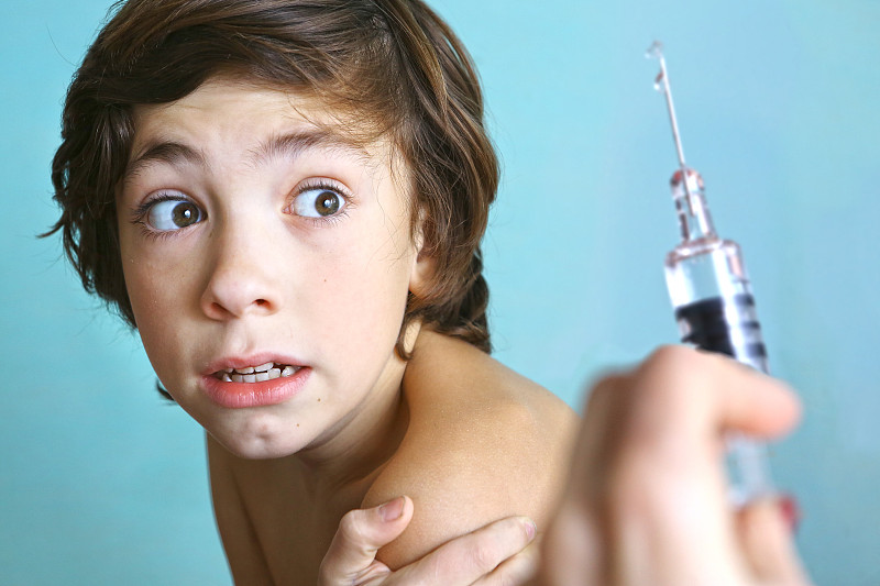 注射器与注射疫苗。男孩害怕。