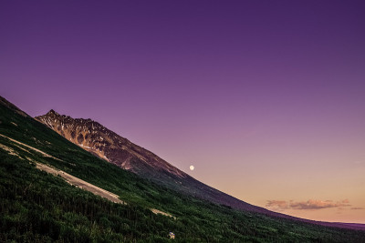 山谷里的满月。紫色的天空。山脉。