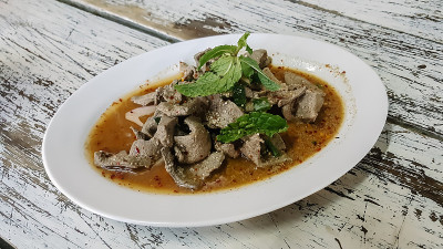 伊桑的食物，烫肝猪肉配辣菜在木桌上，这是泰国最受欢迎的食物之一。