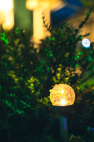 庭院彩灯照明花坛夜景。美丽的小花园与黄灯，灯在花坛。园林设计