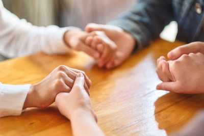 人们手牵着手围成一圈，一起祈祷或在治疗过程中