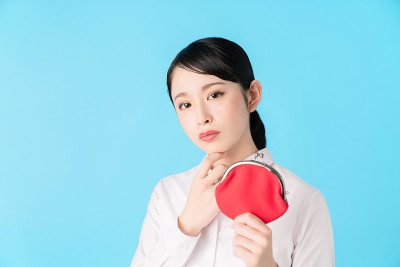 年轻的亚洲女孩拿着一个硬币钱包。
