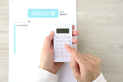 日本的保险单据和人的手与计算器