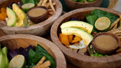 原始和乡村植物为基础的午餐。蔬菜、叶子和牛油果装在木碗里