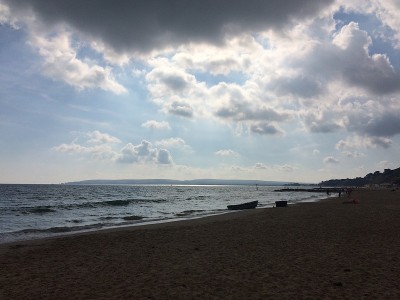 多塞特海滩上的船，云朵和海岬