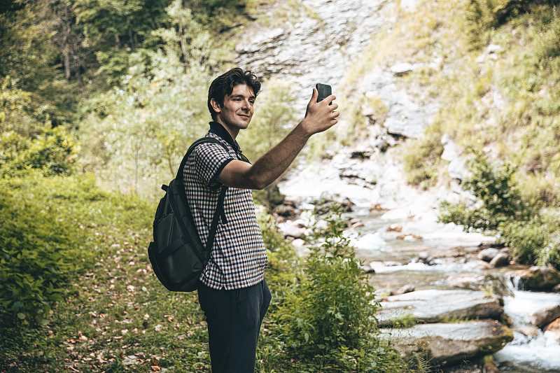 Young Adult Man using phone in Limone Piemonte