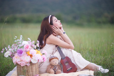 美丽的亚洲女音乐家在自然背景。