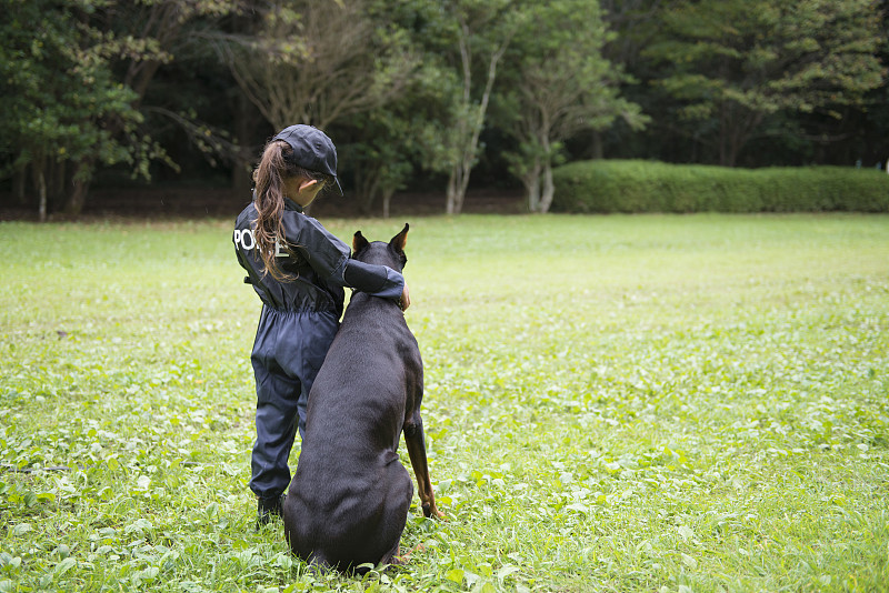 穿着警服的小女孩和buddy Doberman