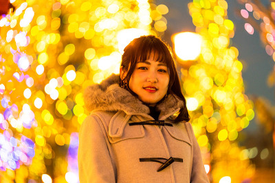 年轻女子站在灯光背景下