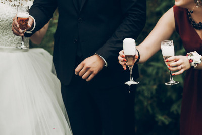 新娘和新郎在婚宴上用香槟杯敬酒。华丽的婚礼夫妇新婚夫妇欢呼，有乐趣和饮酒