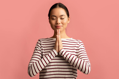 美丽的年轻亚洲女人的肖像与双手合十近脸祈祷