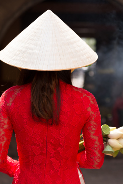 身着奥黛服饰，头戴锥形帽子的妇女