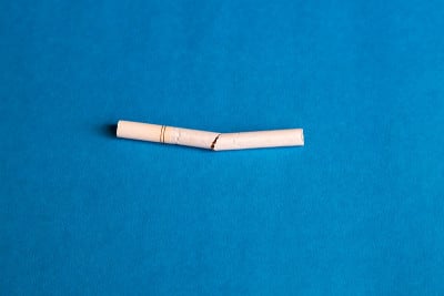 蓝色背景上的破过滤嘴香烟。