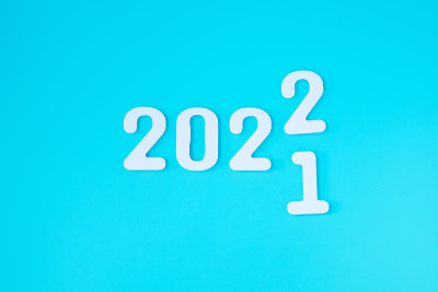 蓝色背景上2021改为2022。计划，财务，决心，策略，解决方案，目标，业务和新年假期的概念