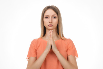 迷人的金发女孩祈祷家人健康，双手合十祈祷