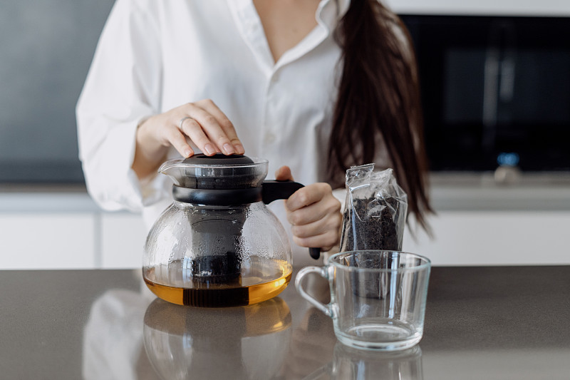 一个女人在厨房用茶壶泡红茶