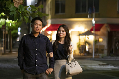 年轻的男人和女人在夜色的城市背景下交叉双臂