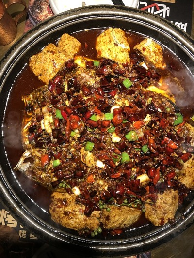 这是中国四川成都的一家当地餐馆，在红辣椒油(中文:马拉辣椒油)中，可以看到川菜的烤鱼和豆腐