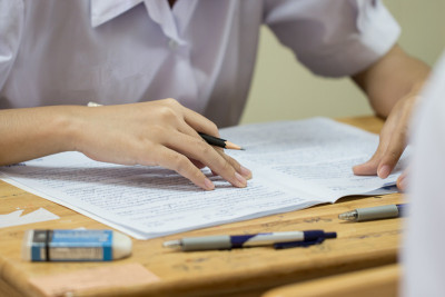 学生在高中使用铅笔阅读信息在白纸上，亚洲的考场，测试或考试是评估旨在衡量知识，技能，天资，教育学习概