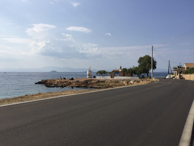 希腊埃伊纳岛沿海公路上的埃伊纳灯塔(Faros Mbouza)和圣使徒教堂。